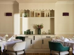 Elegant dining room with set tables and decorative shelves.