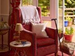 Cosy reading nook with red armchair and side table.