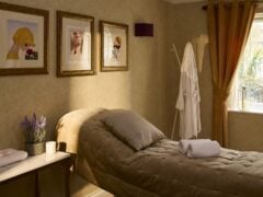 Cosy spa room with massage bed and decor.