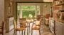 Elegant dining room with garden view and table settings.