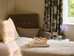 Cosy bedroom with stacked towels and hairbrush.