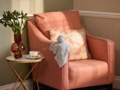 Cosy armchair, table with coffee, knitting and flowers