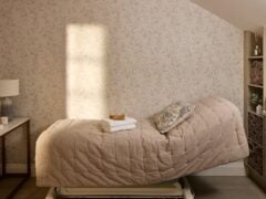 Cosy massage room with decorative wallpaper and blankets.