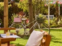 Vintage bicycle with flower baskets in garden