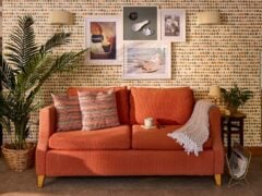 Cosy living room with orange sofa and wall art