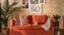 Cosy living room with orange sofa and wall art