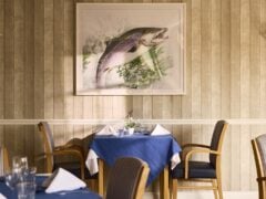 Restaurant table with blue tablecloth and fish painting