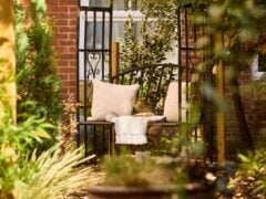 Cosy garden bench with cushions and blanket