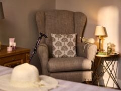 Cosy armchair with cushion and side table lamp