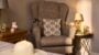 Cosy armchair with cushion and side table lamp