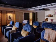 Luxury home cinema with blue velvet chairs.