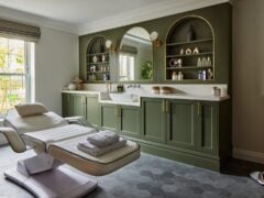 Luxurious green-themed beauty treatment room with windows.