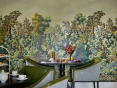 Elegant dining room with scenic wallpaper.