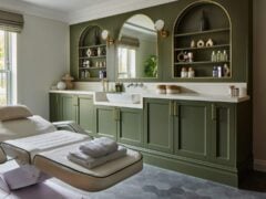 Elegant spa treatment room with green cabinetry.