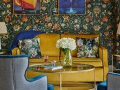 Floral-themed living room with yellow sofa and blue chairs