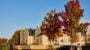 Modern building with autumn trees and cars